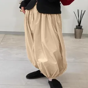 Modern beige balloon harem pants for women featuring a high waist and cinched ankle cuffs.
