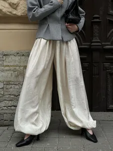 Detail of cream lantern pants with pleated texture and stylish balloon silhouette.