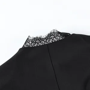 Detailopname van fijn zwart kant op een elegante damesjas of top
