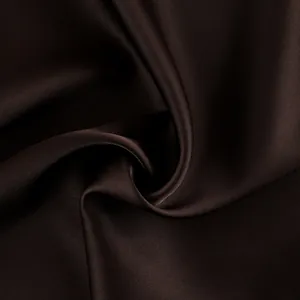 Detailed view of luxurious deep brown satin fabric with soft sheen and elegant draping