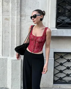 Fashionable red lace corset camisole styled with elegant black trousers and accessories.