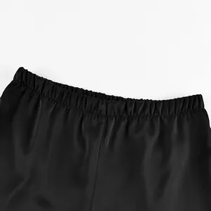 Close-up detail showing the elastic waistband of black satin high waist straight trousers