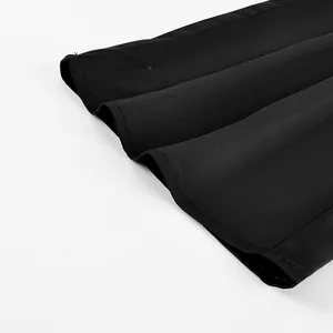 Macro view of black satin fabric trousers hem showing smooth texture and stitching