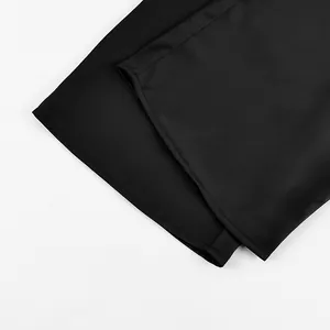 Close-up detail of smooth black satin trouser hem showing clean stitching
