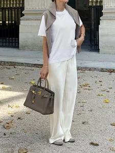 Detailed view of white high waisted acetate satin straight leg trousers for casual commute