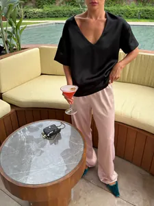 Detailed view of high-waist satin straight-leg trousers with elegant drape