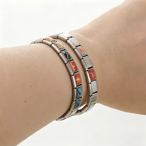 Primo piano di bracciali con charm modulari italiani in acciaio inox smaltato al polso