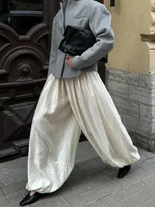 Detailed view of textured cream-colored lantern pants styled for a minimalist chic look