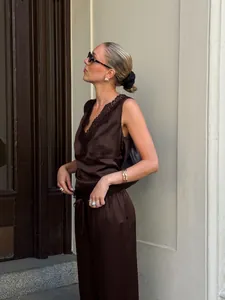 Elegant model wearing a chocolate brown satin two-piece set with lace trim outdoors
