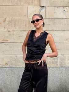 Sophisticated black satin two-piece set featuring deep V-neck lace vest and straight trousers