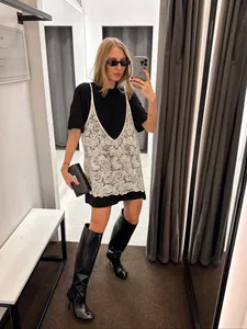 Selfie allo specchio con canotta in pizzo bianco su un mini abito t-shirt nero
