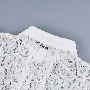 Dettaglio della trama in pizzo floreale bianco e del colletto alla coreana della blusa.