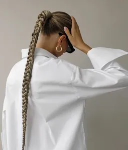 Back view detail of minimalist white oversize shirt showing relaxed fit and wide cuffs
