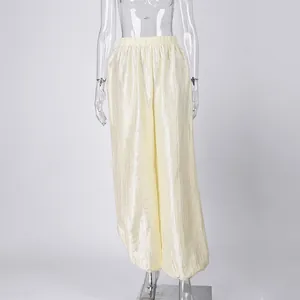 Detailed view of cream metallic sheen harem pants with pleated high waist design