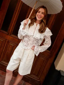 Elegante witte kanten transparante blouse met dubbele ruches gedragen door model