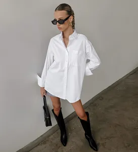 Full view of minimalist oversized white boyfriend-style shirt styled with black boots