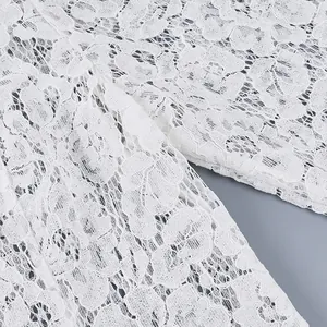 Primo piano del tessuto in pizzo floreale bianco di un'elegante camicetta donna