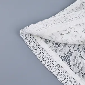Primo piano della trama del pizzo bianco all'uncinetto di una camicia da donna.