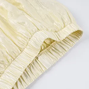 Detailed close-up of elasticized waistband on champagne crinkled satin lantern pants