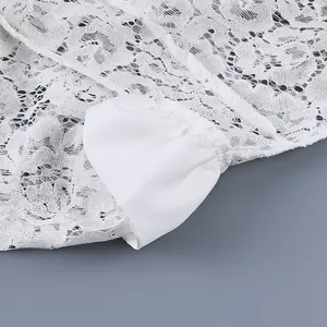 Vista dettagliata del pizzo bianco e del polsino di una camicia da donna