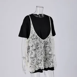 Dettaglio del top in pizzo bianco sovrapposto a una T-shirt nera a maniche corte