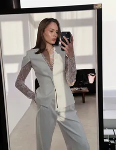 Elegante witte kanten blazer en broek set getoond in een spiegel selfie detail opname.