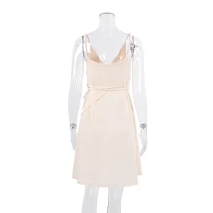 Rear view of a light cream cotton gauze slip dress with delicate tie-waist detail.