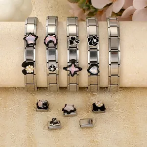 Detail view of stainless steel modular charm bracelets with animal, star, and heart elements
