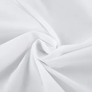 Close-up of high-quality white cotton fabric showing soft texture and drape.