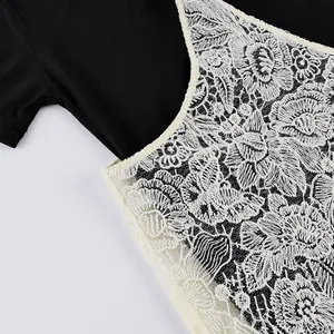 Dettaglio ravvicinato del ricamo in pizzo floreale bianco su un elegante completo nero