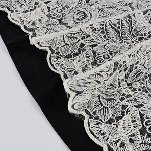 Dettaglio della trama in pizzo floreale su un top a canotta nero elegante.