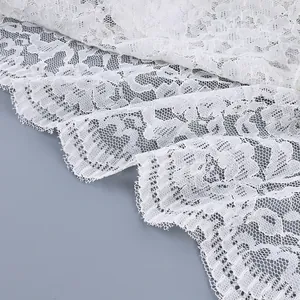Gedetailleerde opname van wit gebloemd kant met een fijne mesh textuur voor kleding.