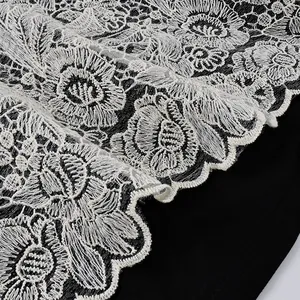 Vista macro dettagliata che mostra l'intricata trama del pizzo floreale bianco sul nero