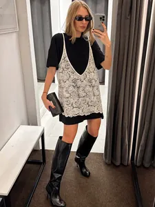 Set due pezzi alla moda con t-shirt nera e canotta in pizzo bianco a fiori.