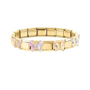 Vue détaillée d'un bracelet modulaire en acier doré avec breloques papillon en résine