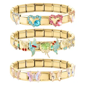 Détail de bracelets modulaires en acier doré avec des breloques papillon et cœur en cristal.