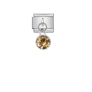 Macro view of a faceted champagne crystal pendant on a stainless steel modular charm link