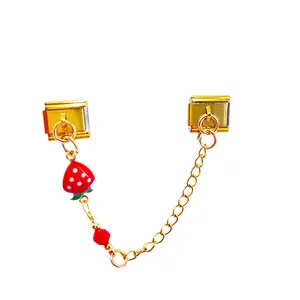 Detail of a gold Italian charm bracelet module featuring a cute red strawberry pendant.