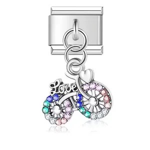 Vista detallada de un charm modular de bicicleta con piedras de colores y grabado Love.