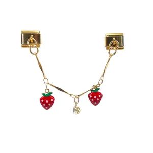 Detail view of gold-toned Italian modular charm with red strawberry pendants and crystal.