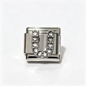 Macro detail of Italian modular bracelet link with crystal-paved letter U design