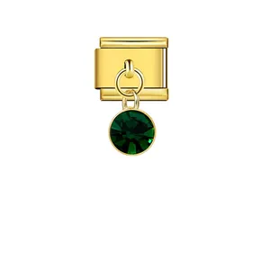 Close-up of a gold Italian modular link charm with a round faceted green gem pendant