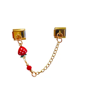 Detail of gold Italian modular charm link with red strawberry pendant and chain.