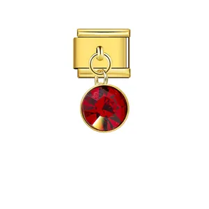 Detail view of a golden Italian modular charm link with a faceted red crystal stone.