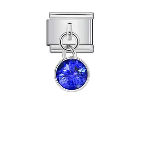Detail of an Italian modular charm with a hanging blue crystal birthstone pendant.