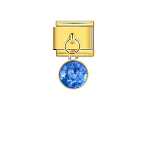 Detailed macro view of a golden Italian modular charm with a round blue crystal pendant