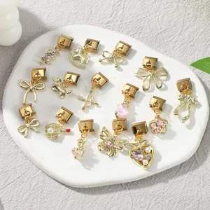 Gros plan de charms italiens dorés DIY avec divers motifs mignons variés