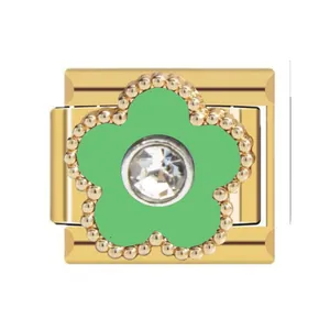 Close-up detail of a gold Italian charm link featuring a green flower with a rhinestone center