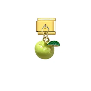 Close-up of a gold Italian modular charm featuring a cute green apple pendant detail.