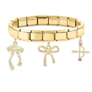 Gros plan d'un bracelet modulaire italien doré avec des breloques élégantes en forme d'arc